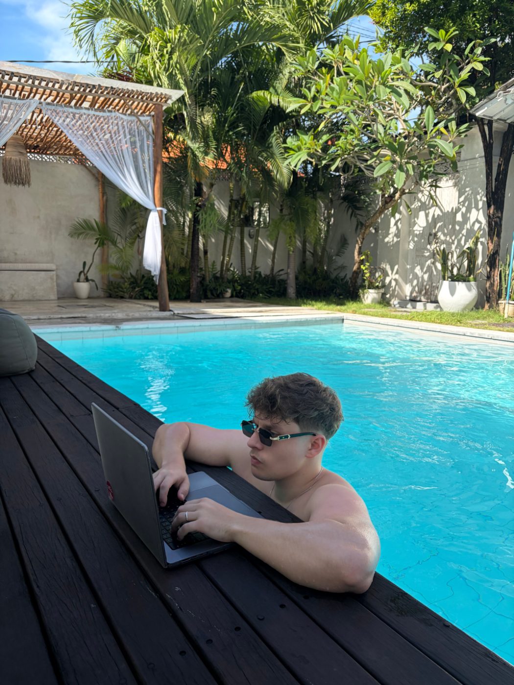 Villi-Pert Peebo working on a laptop by a pool in Bali