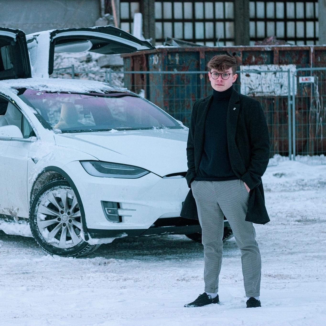 Villi-Pert Peebo beside a Tesla in winter